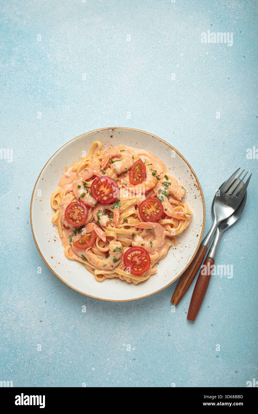 Linguine mit Meeresfrüchten in einer cremigen Sauce mit Garnelen und Tomaten Stockfoto