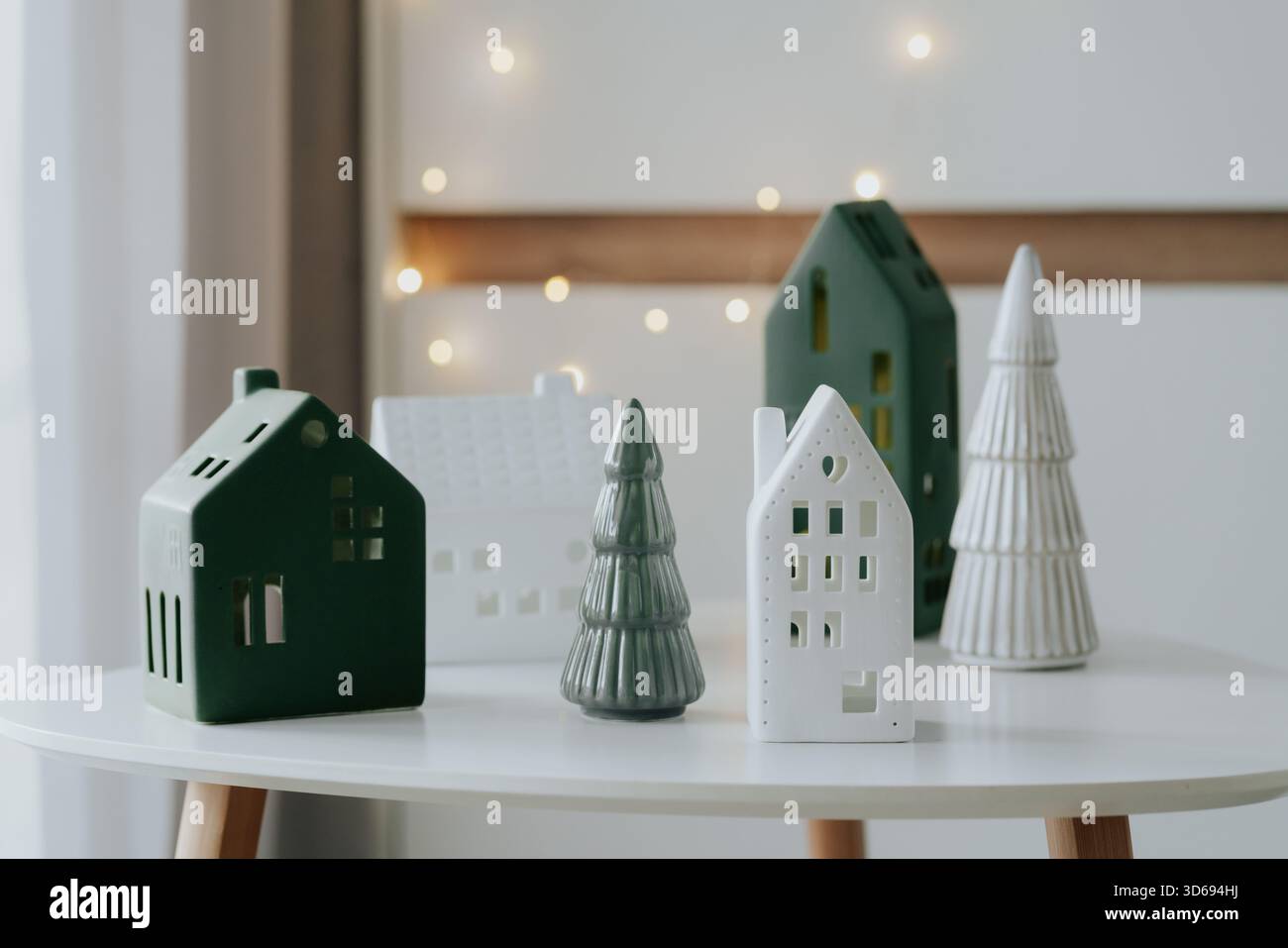 Modernes Weihnachtsliegerleben mit dekorativen Lichthäusern und warmen Bokeh-Lichtern. Stockfoto