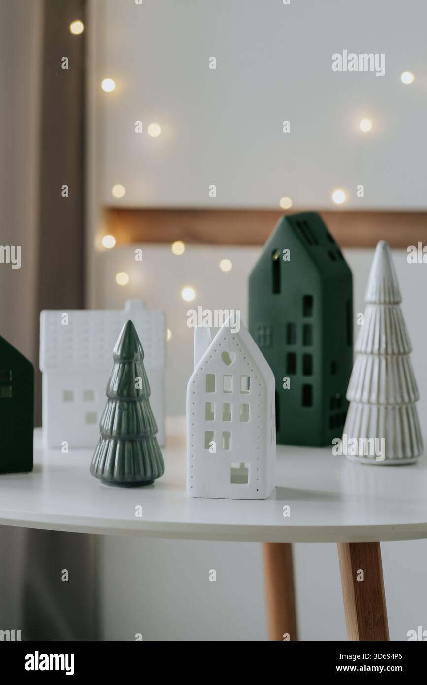 Modernes Weihnachtsliegerleben mit dekorativen Lichthäusern und warmen Bokeh-Lichtern. Stockfoto