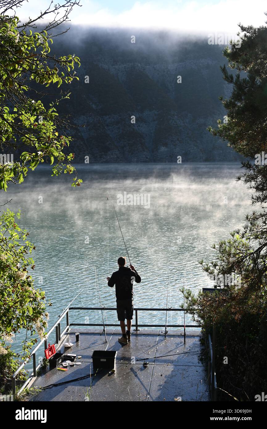 Süßwasser-Fischer, Angler, Fischer oder grober Fischer, Silhouetten auf der Angelplattform am frühen Morgen auf dem Misty Lake Castillon Verdon Provence Frankreich Stockfoto