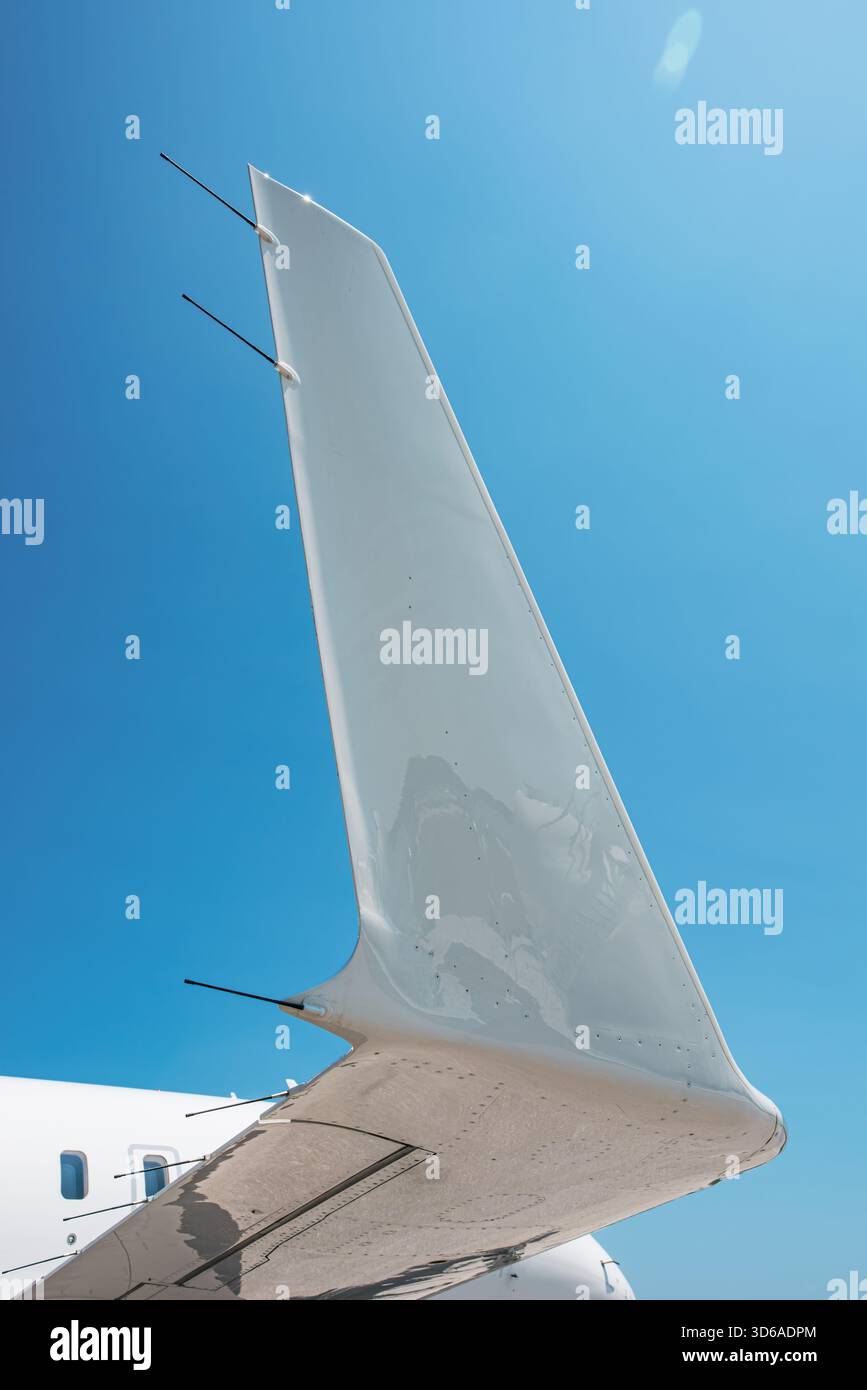 Nahaufnahme der Flügelspitze eines Business-Jets aus einem niedrigen Winkel, die die glatte aerodynamische Oberfläche, die Antennen und die reflektierende Oberfläche wieder zeigt Stockfoto