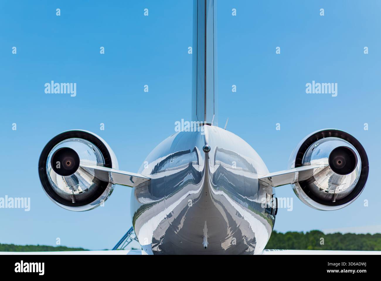 Zentrierte Rückansicht eines Privatjets mit beiden Motoren, Heckteil, polierten Oberflächen und klarer Himmelsbeleuchtung aus gerader Position. Stockfoto