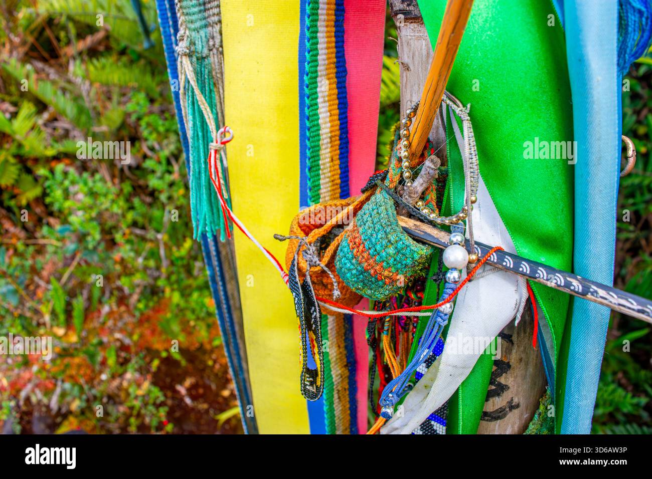 Lebendige Bänder und handgefertigtes Kunsthandwerk, das an einem Stock gebunden ist, repräsentieren kulturelle Angebote in der malerischen Region Purace in Kolumbien. Stockfoto