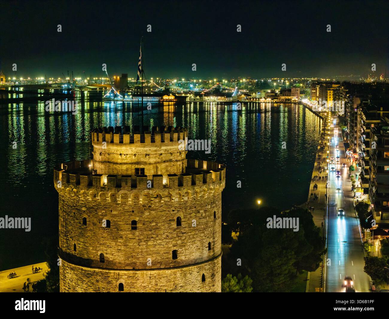 Thessaloniki, Griechenland, 27. Oktober 2025. Der Weiße Turm leuchtet am Meer, während Geschichte und Nachtleben entlang der Uferpromenade in einer Stadt verschmelzen, die nie aufhört Stockfoto