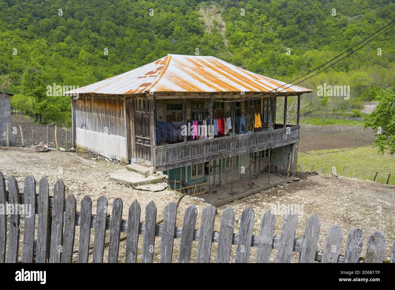 Altes Holzhaus mit Veranda und farbenfroher Wäscherei, ländliche Gegend, Imereti Region, Imereti, Georgia Stockfoto