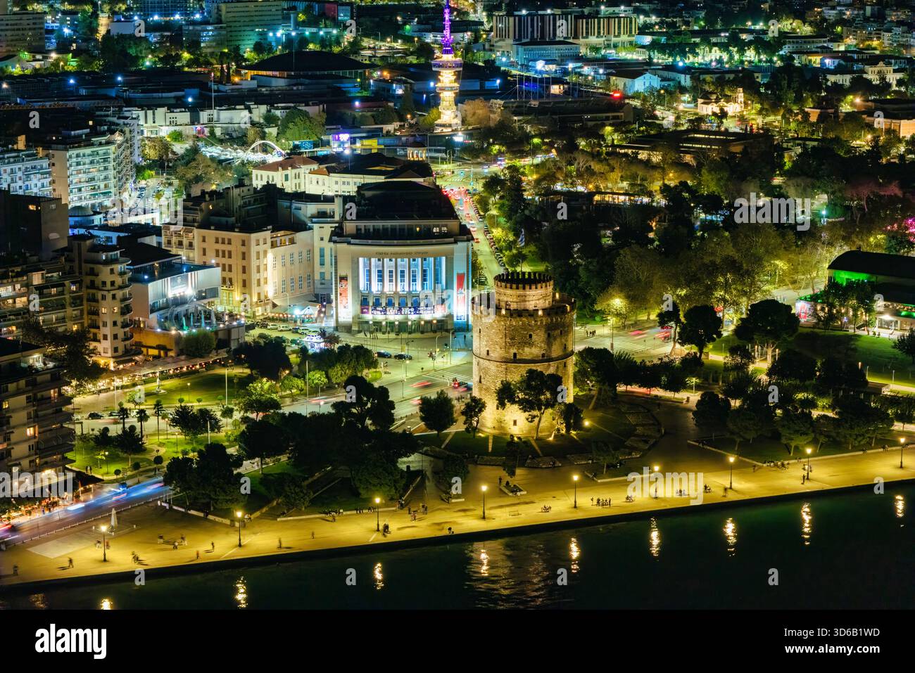Thessaloniki, Griechenland, 27. Oktober 2025. Der Weiße Turm leuchtet am Meer, während Geschichte und Nachtleben entlang der Uferpromenade in einer Stadt verschmelzen, die nie aufhört Stockfoto