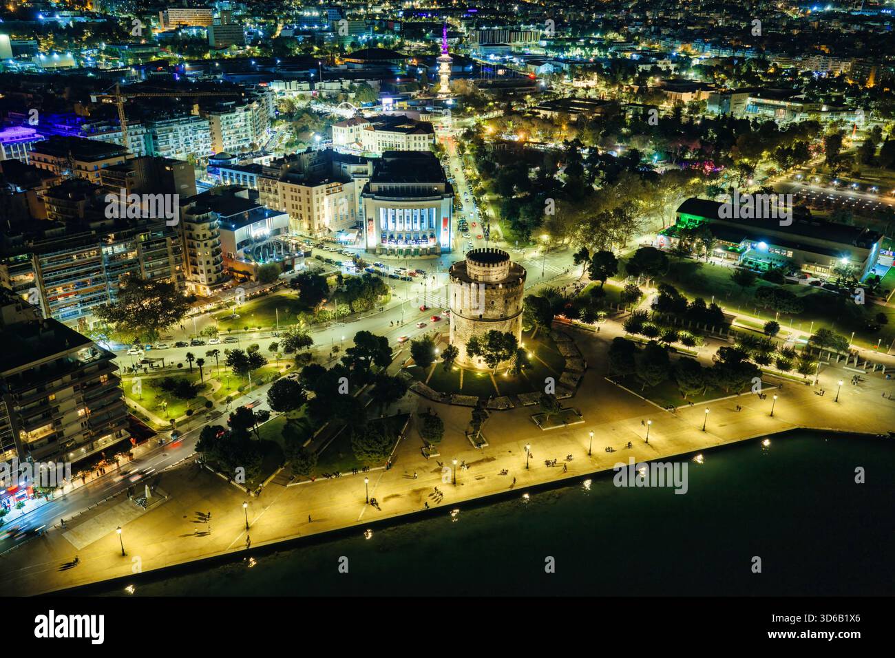 Thessaloniki, Griechenland, 27. Oktober 2025. Der Weiße Turm leuchtet am Meer, während Geschichte und Nachtleben entlang der Uferpromenade in einer Stadt verschmelzen, die nie aufhört Stockfoto