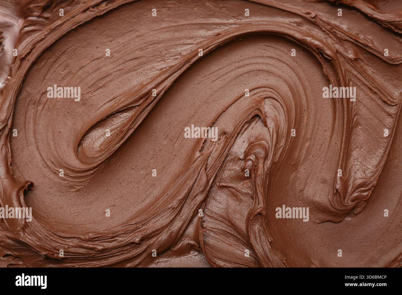 Cremiger Wirbel aus geschmolzener Milchschokolade als Hintergrund Stockfoto