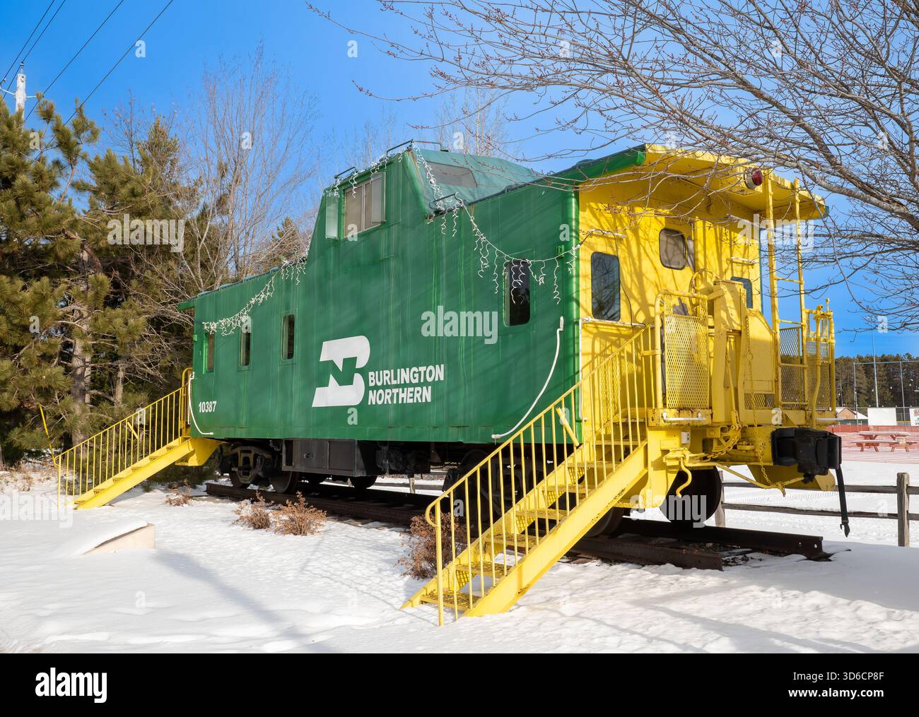 NISSWA MN - 24. Dezember 2021: Grüne Zugkaboose mit gelber Besatz an sonnigen Wintertagen ist eine Touristenattraktion in Minnesota. Stockfoto