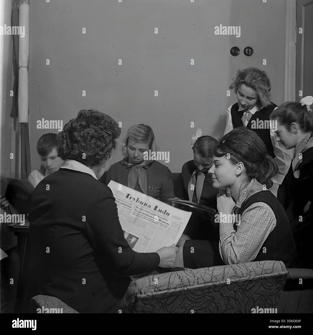 Slawjansk, Ukraine, UdSSR - 1970er Jahre: Authentisches Archivfoto einer politischen Informationsveranstaltung im Polnisch-sowjetischen Freundschaftsraum. Eine Lehrerin liest die polnische Zeitung Trybuna Ludu vor einer Gruppe aufmerksamer Schüler, die in Sesseln sitzen. In der sichtbaren Überschrift wird "Sesja naukowa na Wawelu" erwähnt. Dieses Schwarzweiß-Bild fängt die ideologische Bildung, den Zugang zur ausländischen Presse und den kulturellen Austausch in der Donezker Region während der friedlichen Sowjetzeit ein. Stockfoto
