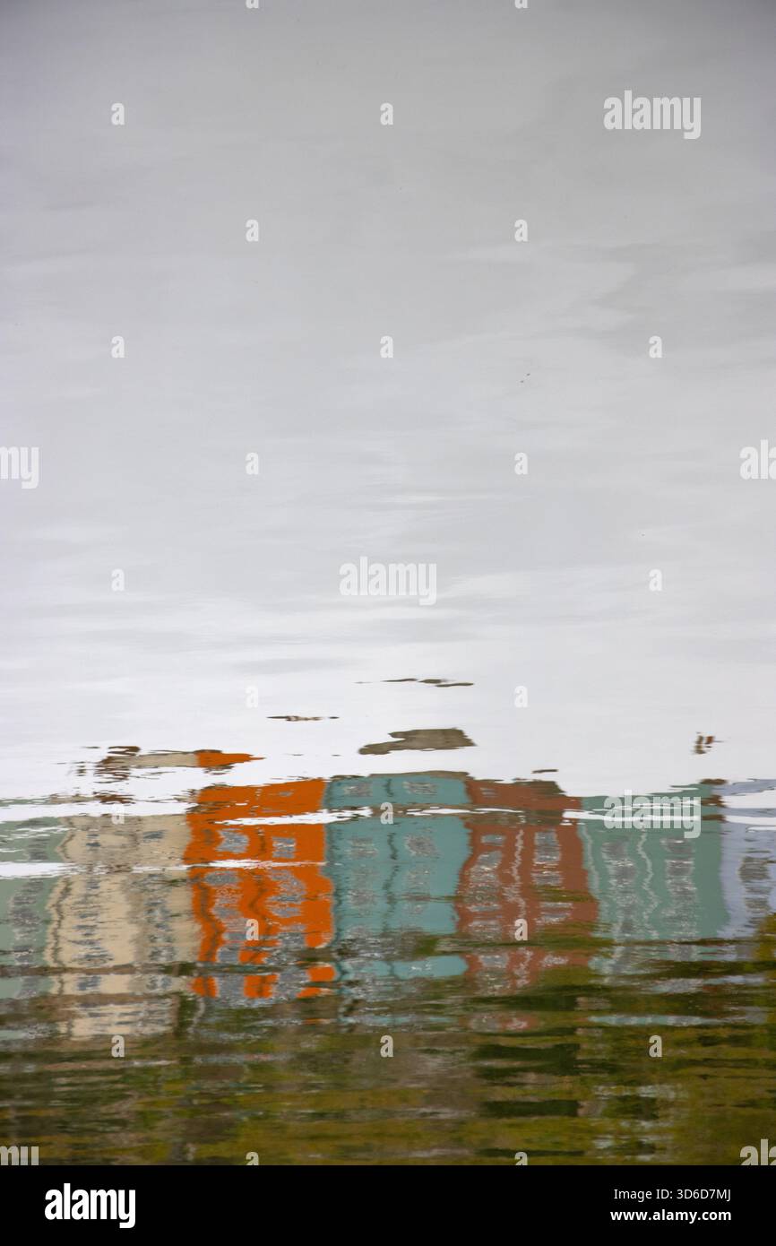 Abstrakte Reflexion farbenfroher quadratischer Häuser in ruhiger Wasseroberfläche Stockfoto