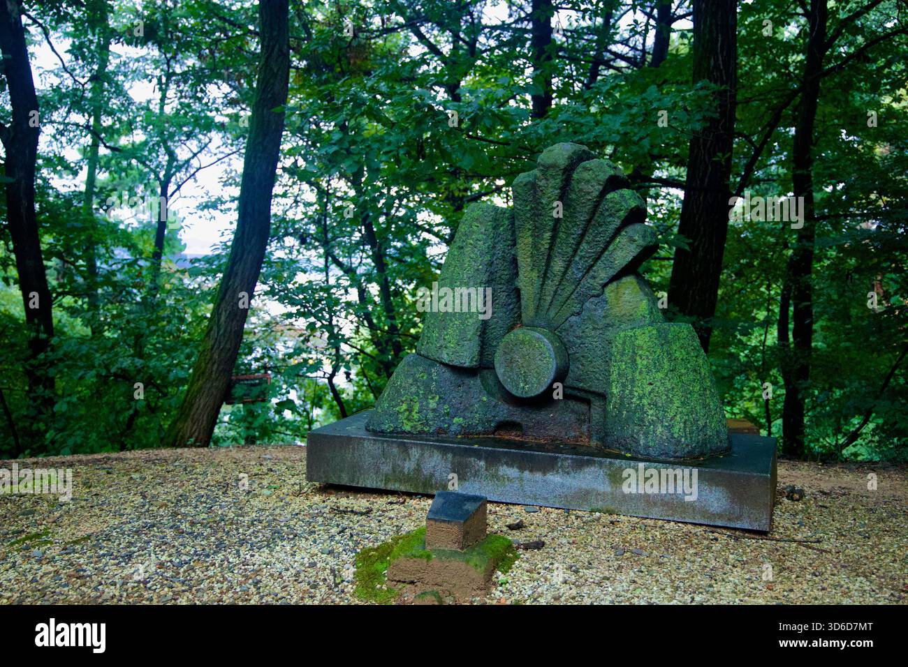 Eine fächerförmige abstrakte Steinskulptur steht in den Wäldern des Tangeumdae Park, deren Oberflächen von Moos und Witterungseinflüssen verdunkelt sind. Stockfoto