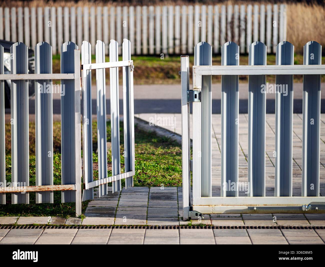 Ein Metallzaun und eine Eingangstür offen gelassen, sonniges Tageslicht Stockfoto