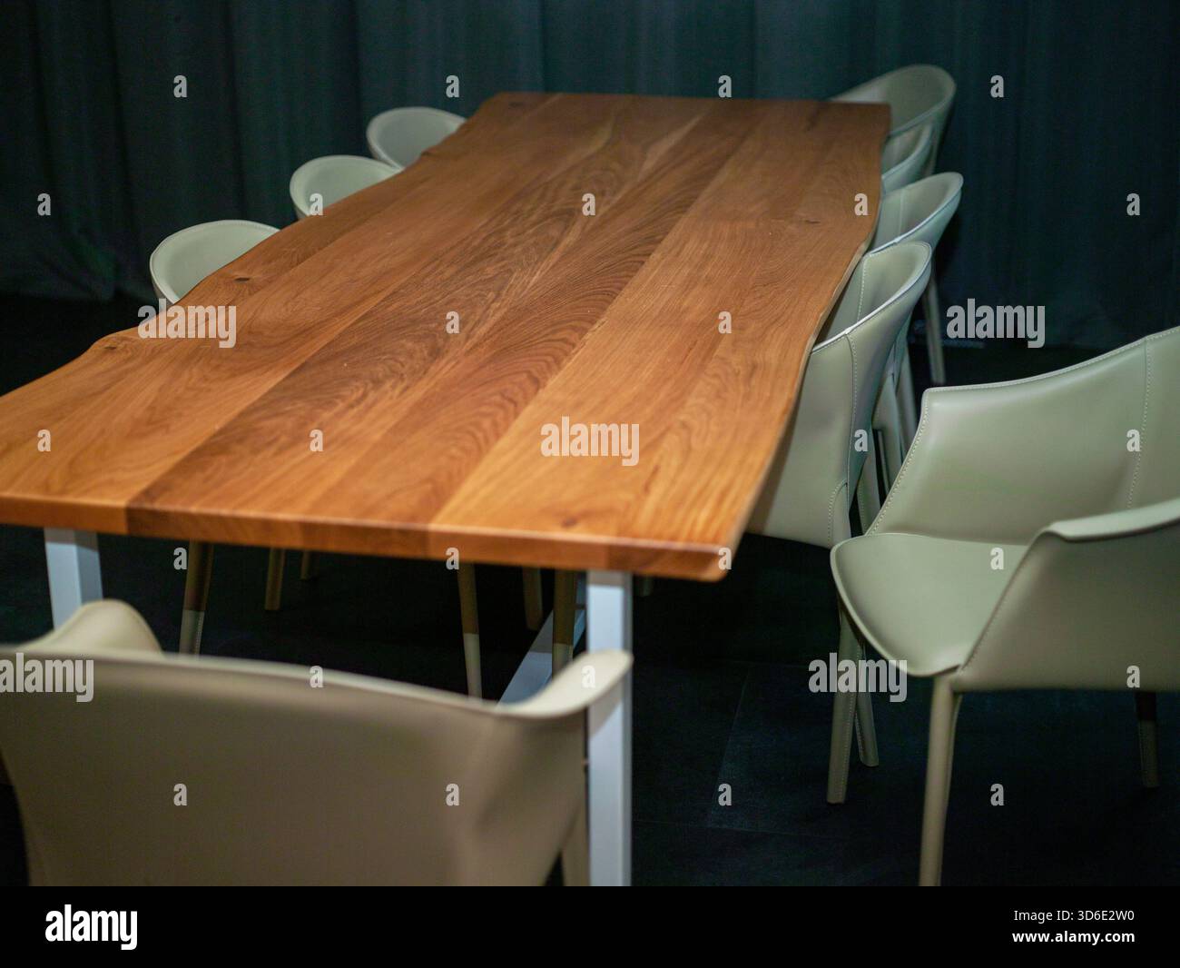 Langer Ess- oder Bürotisch mit Holztisch und Stühlen in einem dunklen Raum Stockfoto
