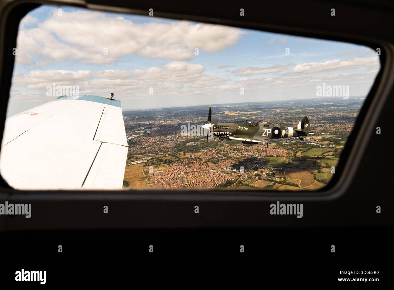 Hampshire, England - 9. August 2025: Aus der Vogelperspektive eines alten Kampfflugzeugs, das vom Fenster eines anderen Flugzeugs aus gesehen wird, mit einem Flickwerk Stockfoto