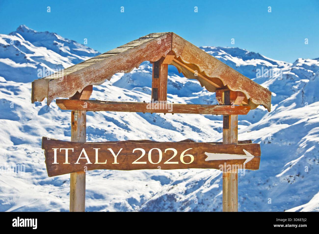 ITALIEN 2026 auf einem hölzernen Richtungsschild geschrieben, verschneite Berglandschaft, Winterspiele, Sportveranstaltungen in Italien Stockfoto