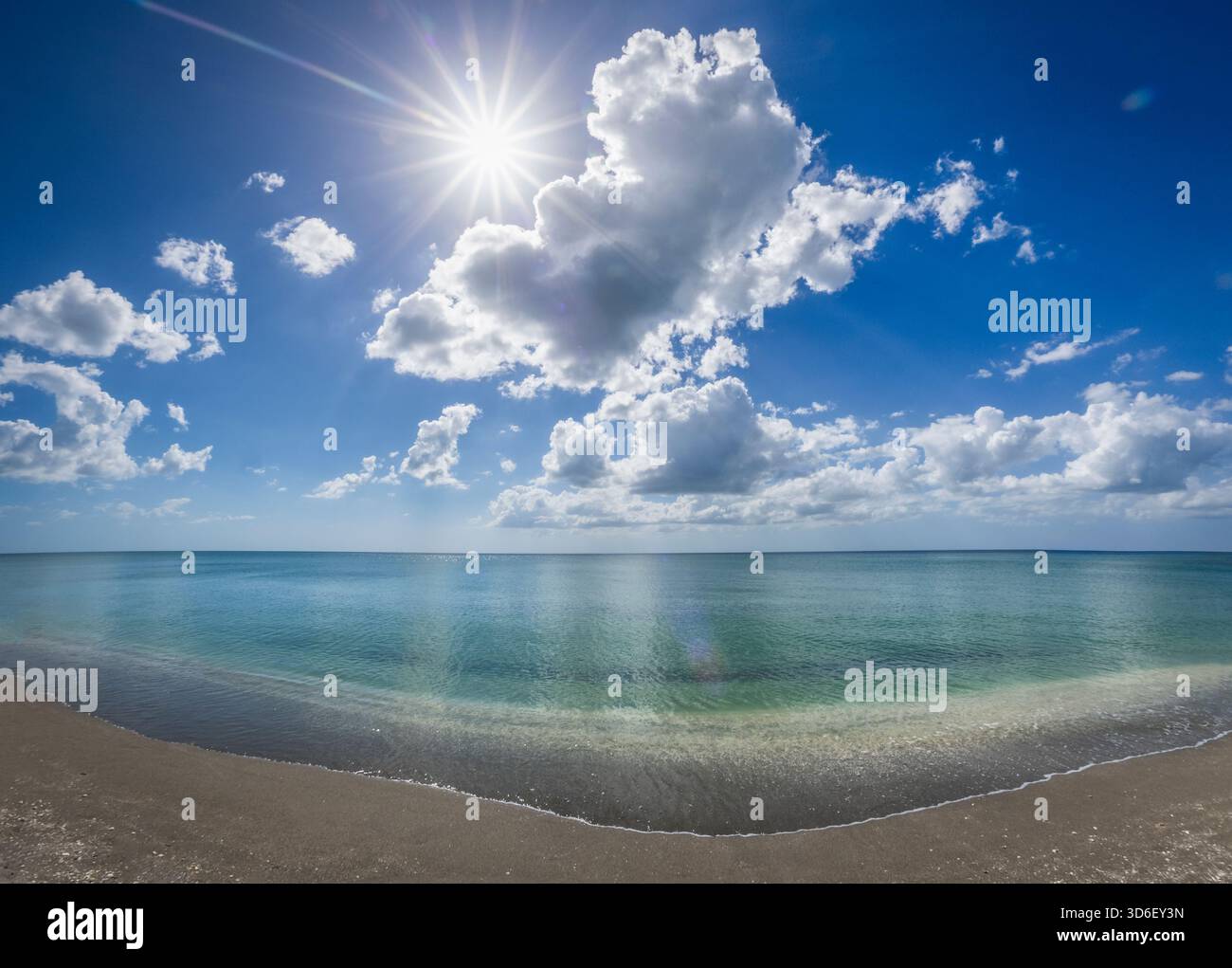 Blauer Himmel weiße Wolken und Sonne über dem ruhigen Golf von Amerika formell der Golf von Mexiko vom Strand in Venedig Florida USA Stockfoto