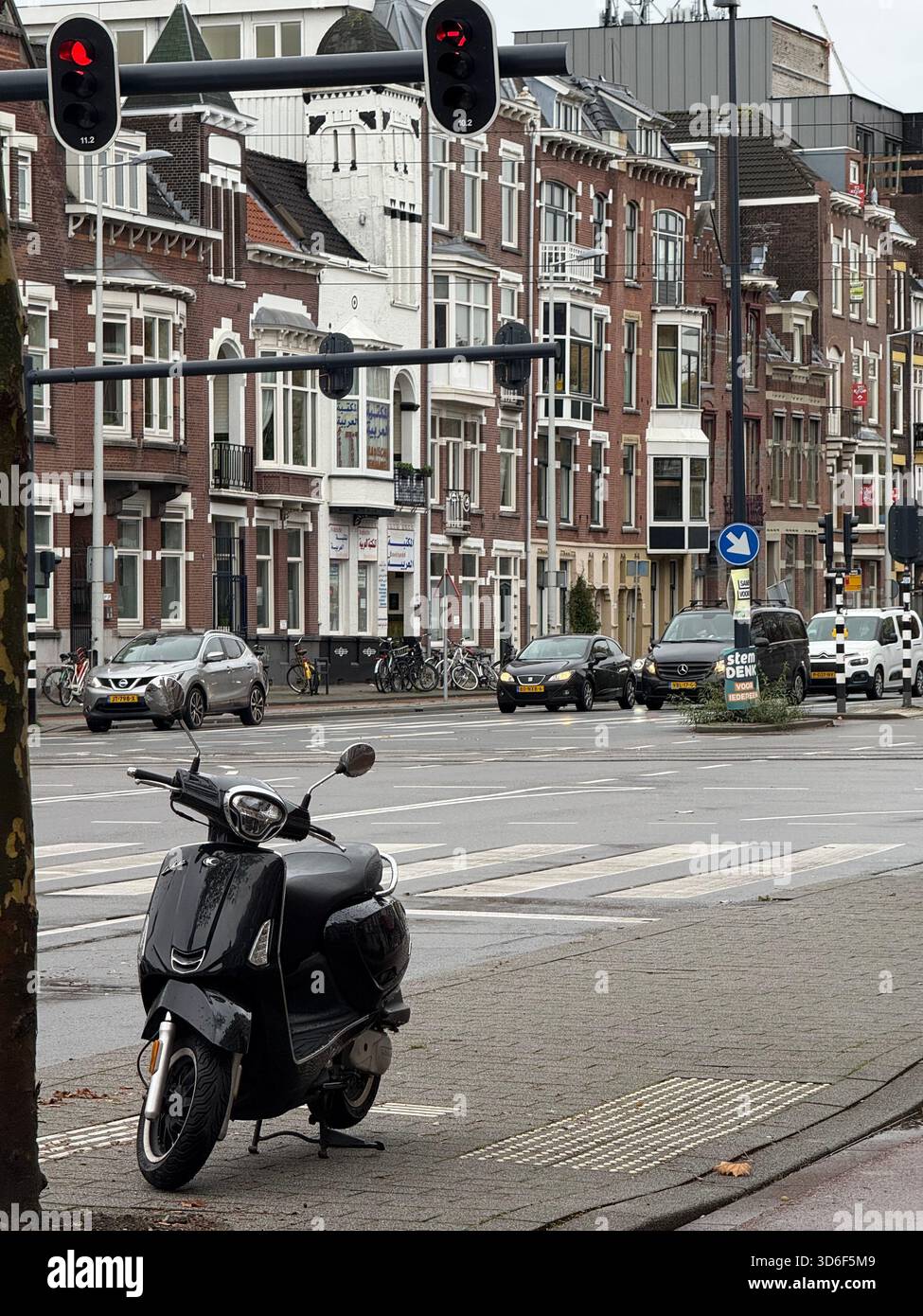 Blick auf die Innenstadt von Rotterdam mit traditioneller niederländischer Backsteinarchitektur, Ampeln und städtischer Verkehrsinfrastruktur an einem bewölkten Tag - Smartphone-aufgenommenes Stockfoto