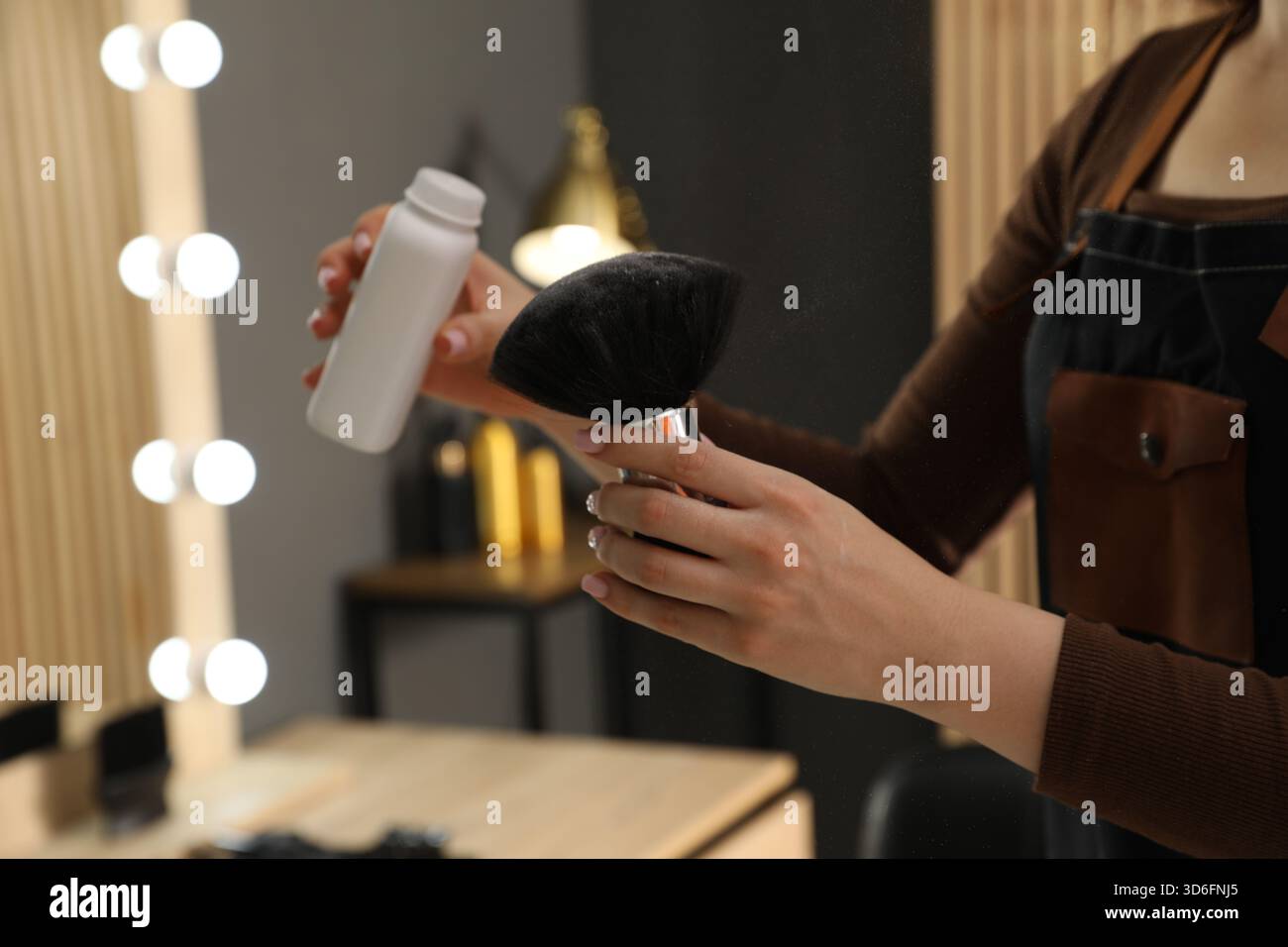 Friseure, die Talkumpuder auf die Bürste im Salon, Nahaufnahme Stockfoto