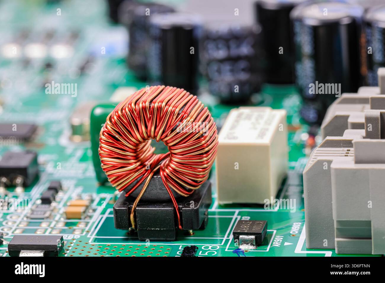 Kupferspule oder Induktivitätsspule auf Leiterplatte, elektronische Bauteile in elektronischen Geräten. Stockfoto