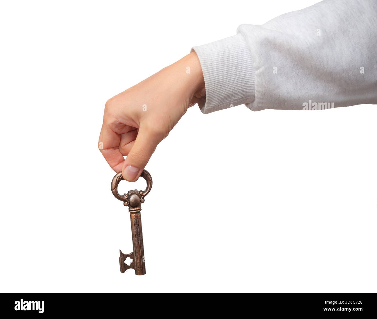 Eine Hand hält einen alten Schlüssel, der den Moment des Betretens eines neuen Hauses symbolisiert. Die Begeisterung beim Kauf von Immobilien liegt in der Luft. Stockfoto