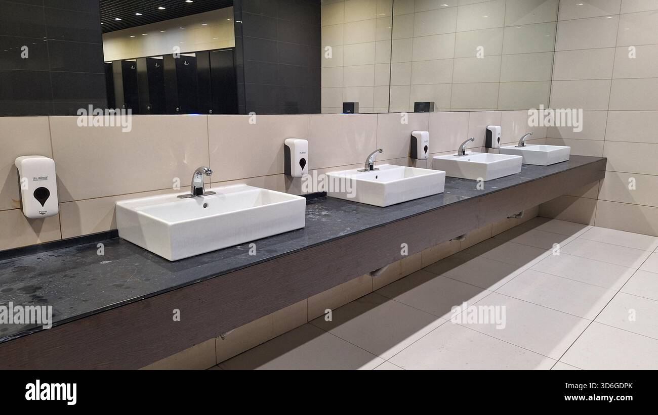 Russland, Moskau - 22. Oktober 2025. Moderne öffentliche Toiletten mit eleganten Waschbecken, Seifenspendern und einem sauberen, minimalistischen Design Stockfoto