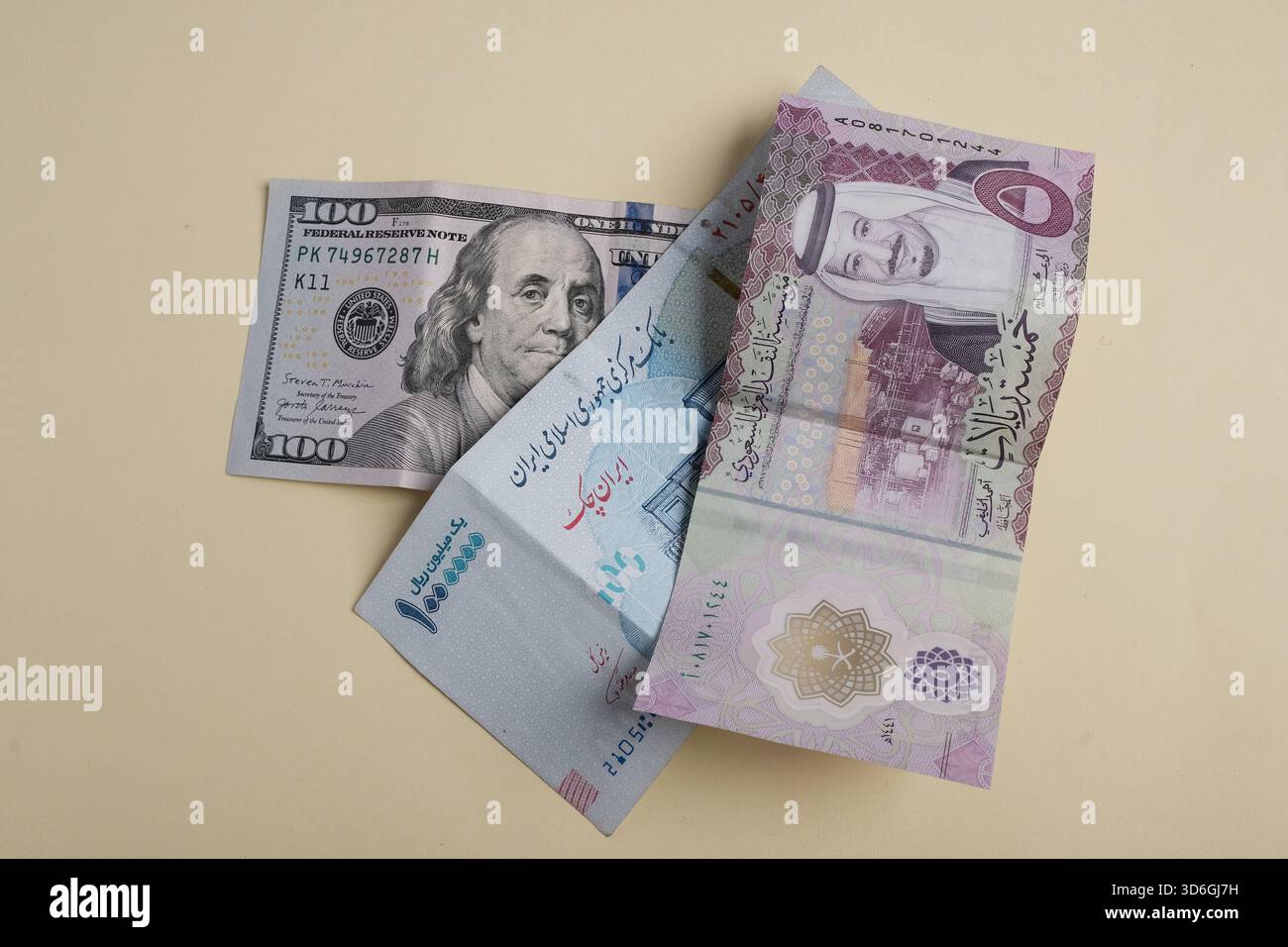 Eine Sammlung verschiedener Banknoten, darunter ein 100-Dollar-Schein, eine Währungsnote aus einem arabischen Land und eine weitere Banknote mit arabischer Schrift Stockfoto