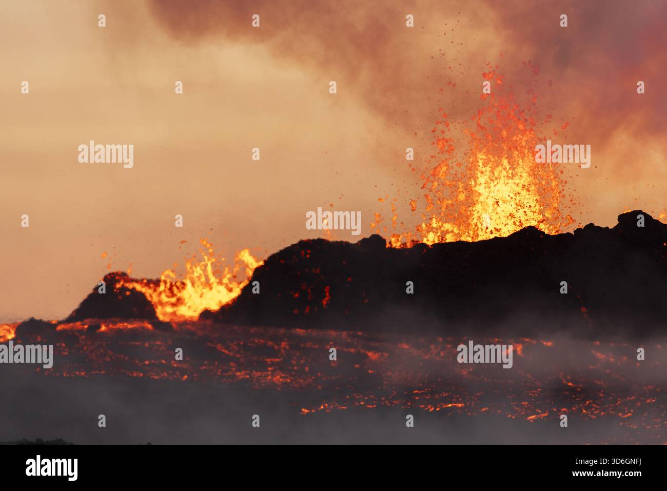 Blick auf geschmolzene Lava fließt wie feurige Flüsse durch die dunkle Landschaft, die mit einer orangen Flamme gegen einen rauchigen Himmel ausbricht, Reykjanes, Grindavík Stockfoto