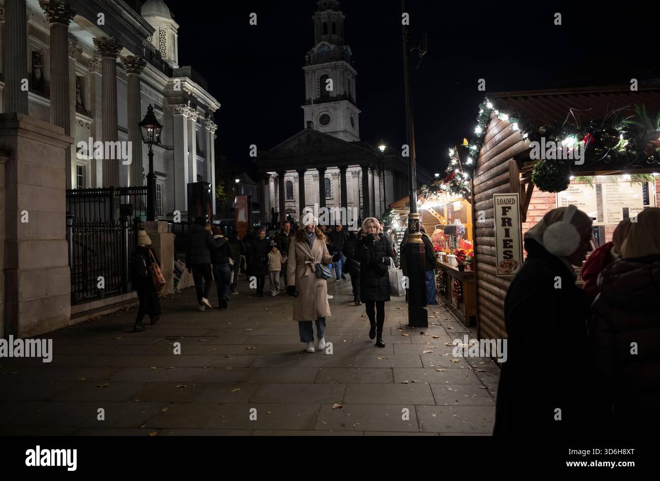 Weihnachten in London 2025 genießen Touristen die Feierlichkeiten auf dem Londoner Weihnachtsmarkt am Trafalgar Square in London, England, Großbritannien Stockfoto