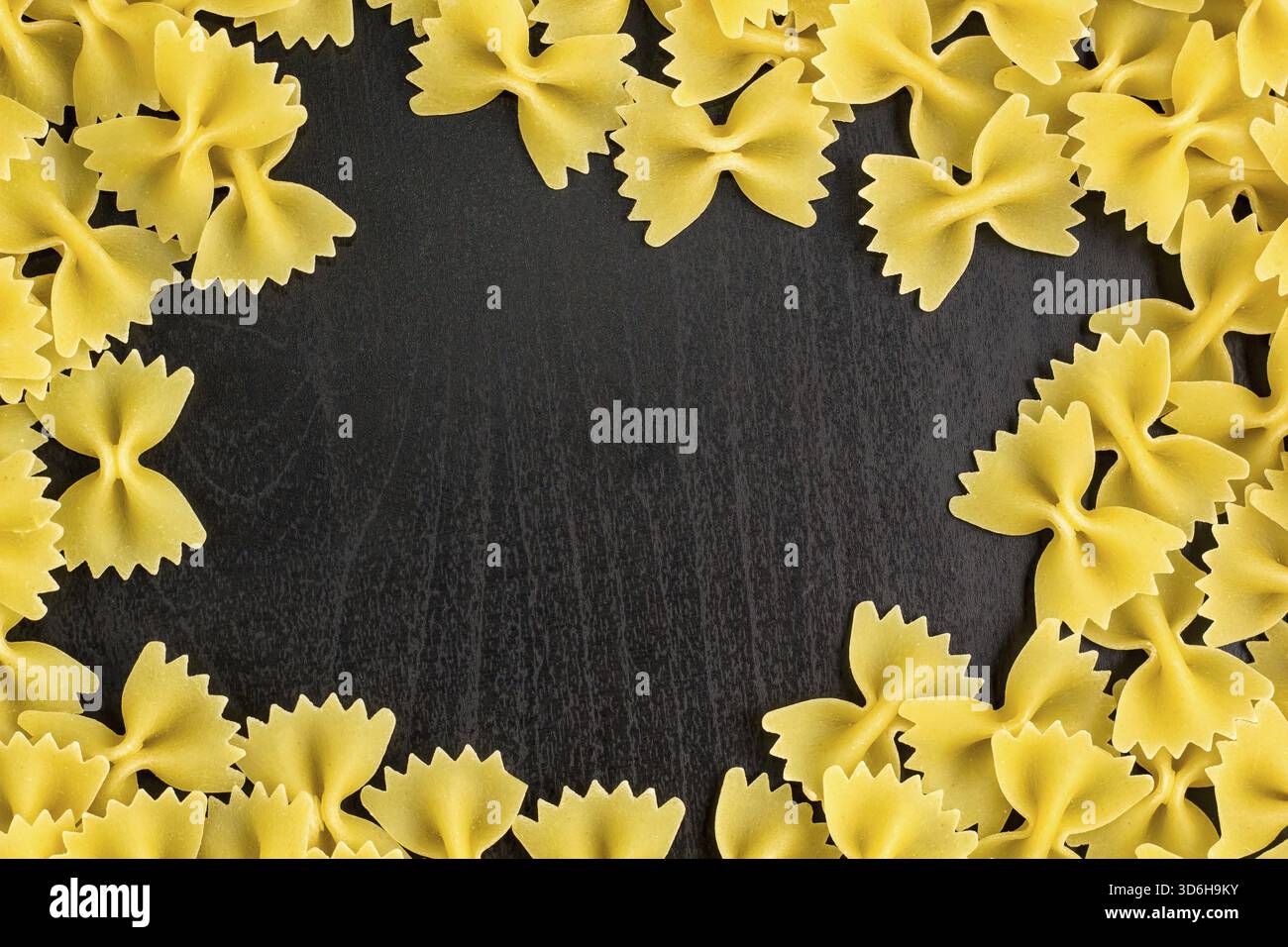 Essen, Rahmen Eines Stapels Farfalle Pasta auf dunklem schwarzem Hintergrund mit Copyspace Stockfoto