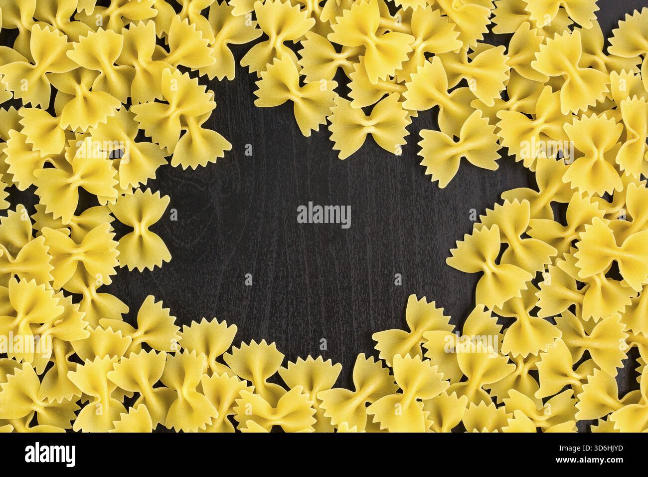 Essen, Rahmen Eines Stapels Farfalle Pasta auf dunklem schwarzem Hintergrund mit Copyspace Stockfoto