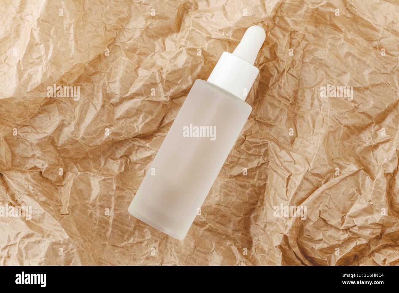 Hyaluronsäure-Tinktur auf gefaltetes Karton. Serum mit Kollagen und Peptiden auf zerknittertem Papier. Modellbau für Schönheitsprodukte. Anti-Aging, Körperpflege Stockfoto