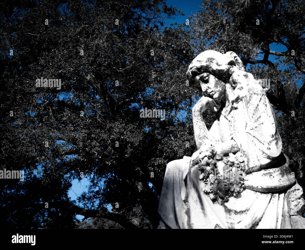 Verwitterte Steinstatue einer besinnlichen Frau, die ihren Kopf auf einer Hand auflegt und einen Blumenkranz hält. Die Abbildung ist dunkel hervorgehoben. Stockfoto