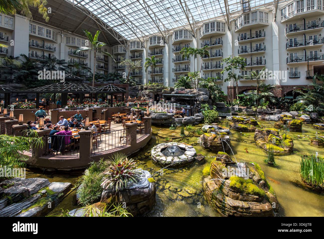 Indoor Atrium Restaurant im Luxury Hotel Resort mit Garden Pond, People Dining und entspannter Atmosphäre Stockfoto