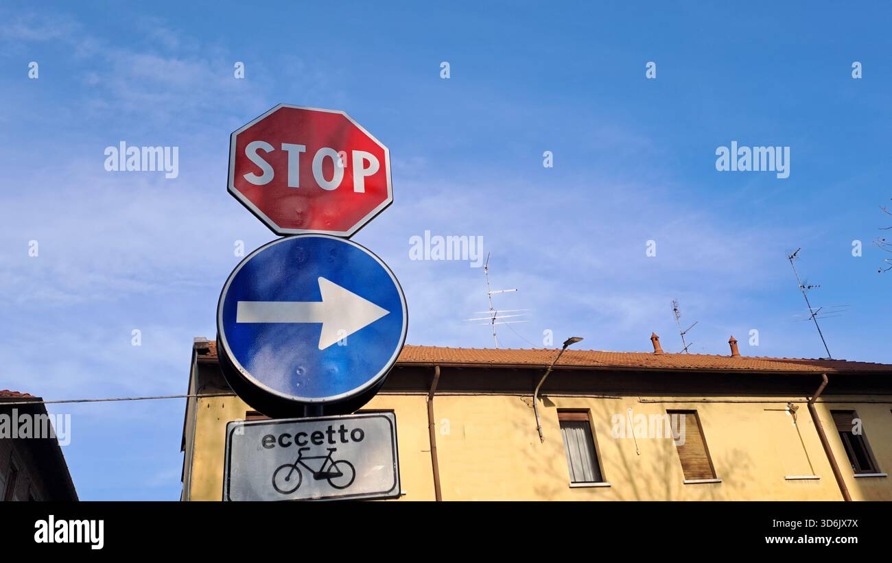 Straßenschild mit vertikalem STOPP und obligatorischer Rechtskurve, außer für Fahrräder, Italien. Stockfoto