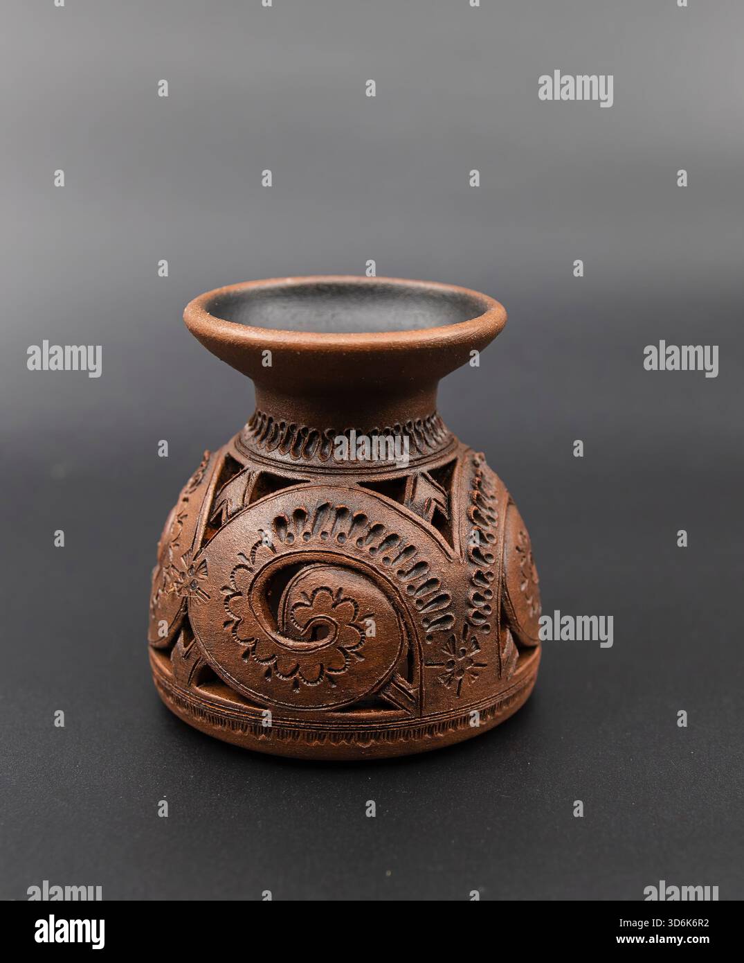 Handgefertigte dekorative Vase aus Ton mit kunstvollen, geschnitzten Blumenmustern für den Innenraum Stockfoto