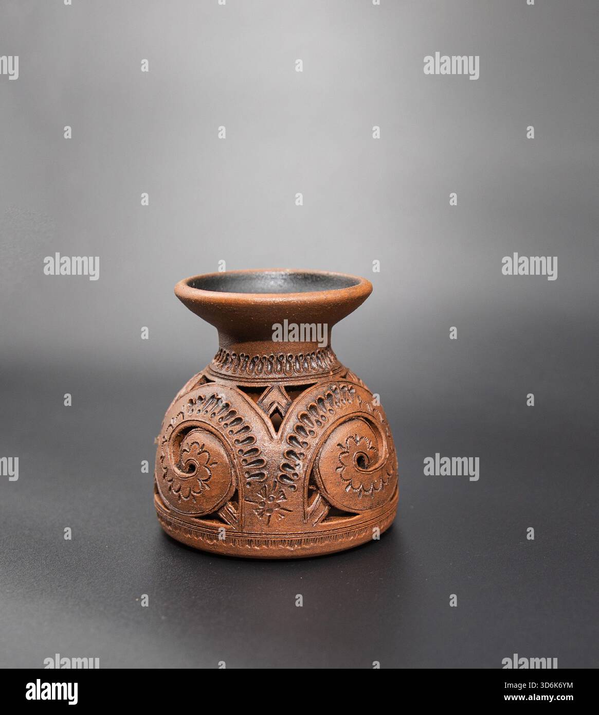 Handgefertigte dekorative Vase aus Ton mit kunstvollen, geschnitzten Blumenmustern für den Innenraum Stockfoto