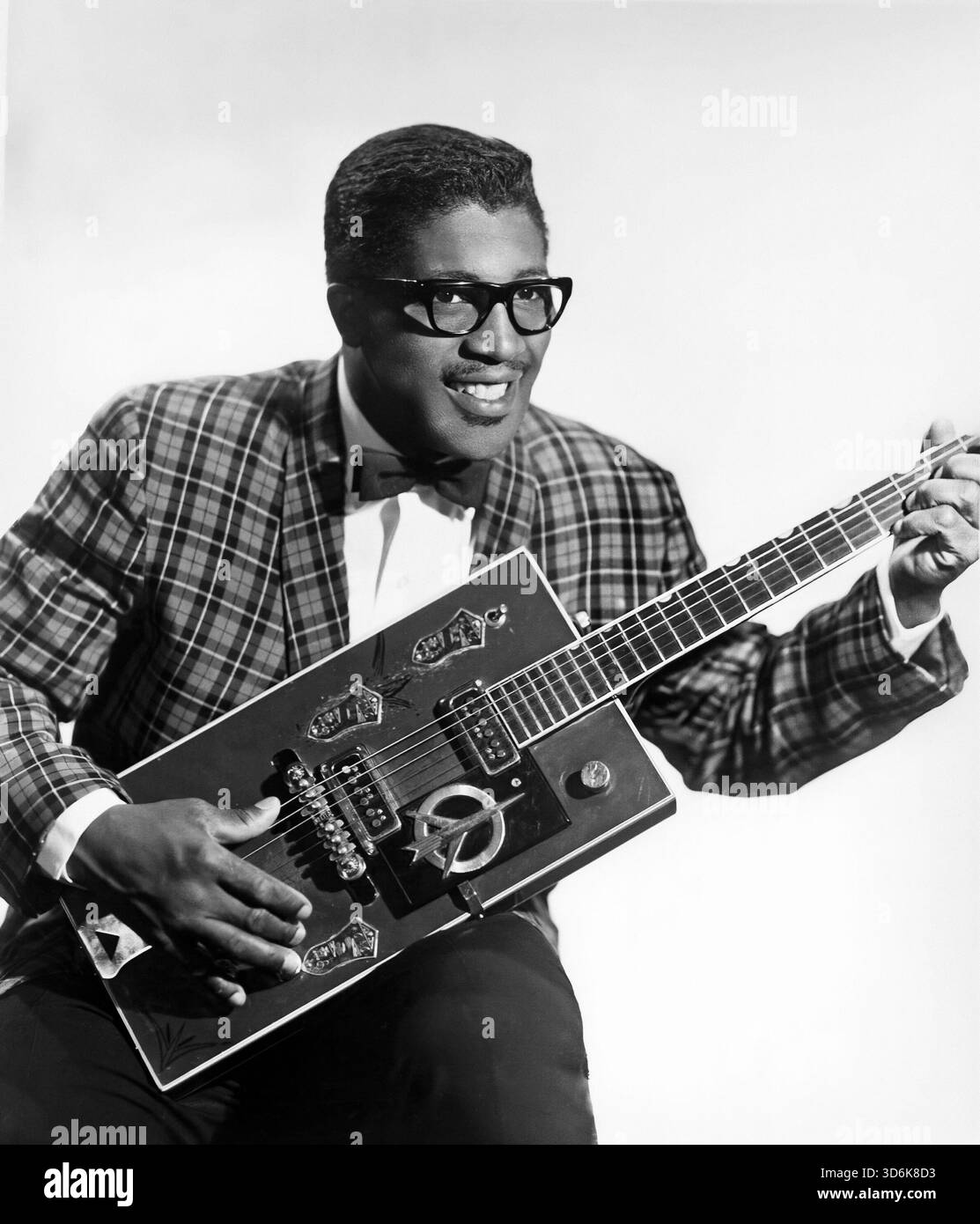 Publicity-Porträt des US-amerikanischen Bluesmusikers Bo Diddley, 1957, sitzend mit seiner „Twang Machine“, einer einzigartigen quadratischen elektrischen Gitarre, die Gretsch für ihn gebaut hat Stockfoto