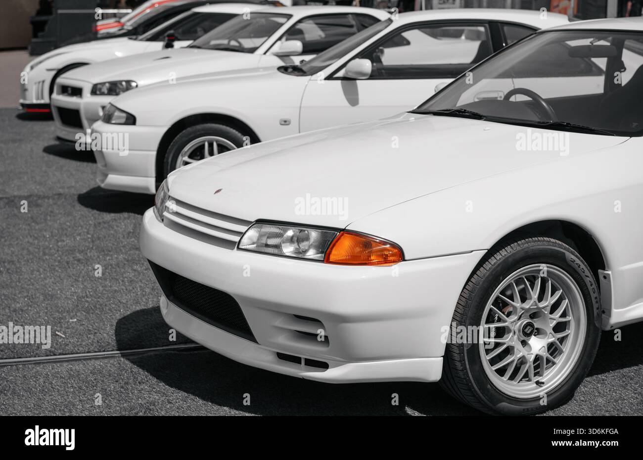 Vier Nissan Skyline GT-RS verschiedener Generationen. Horizontales Bild von Nissan-Autos der 1990er bis 2000er Jahre an einem sonnigen Tag auf dem Parkplatz. Stockfoto