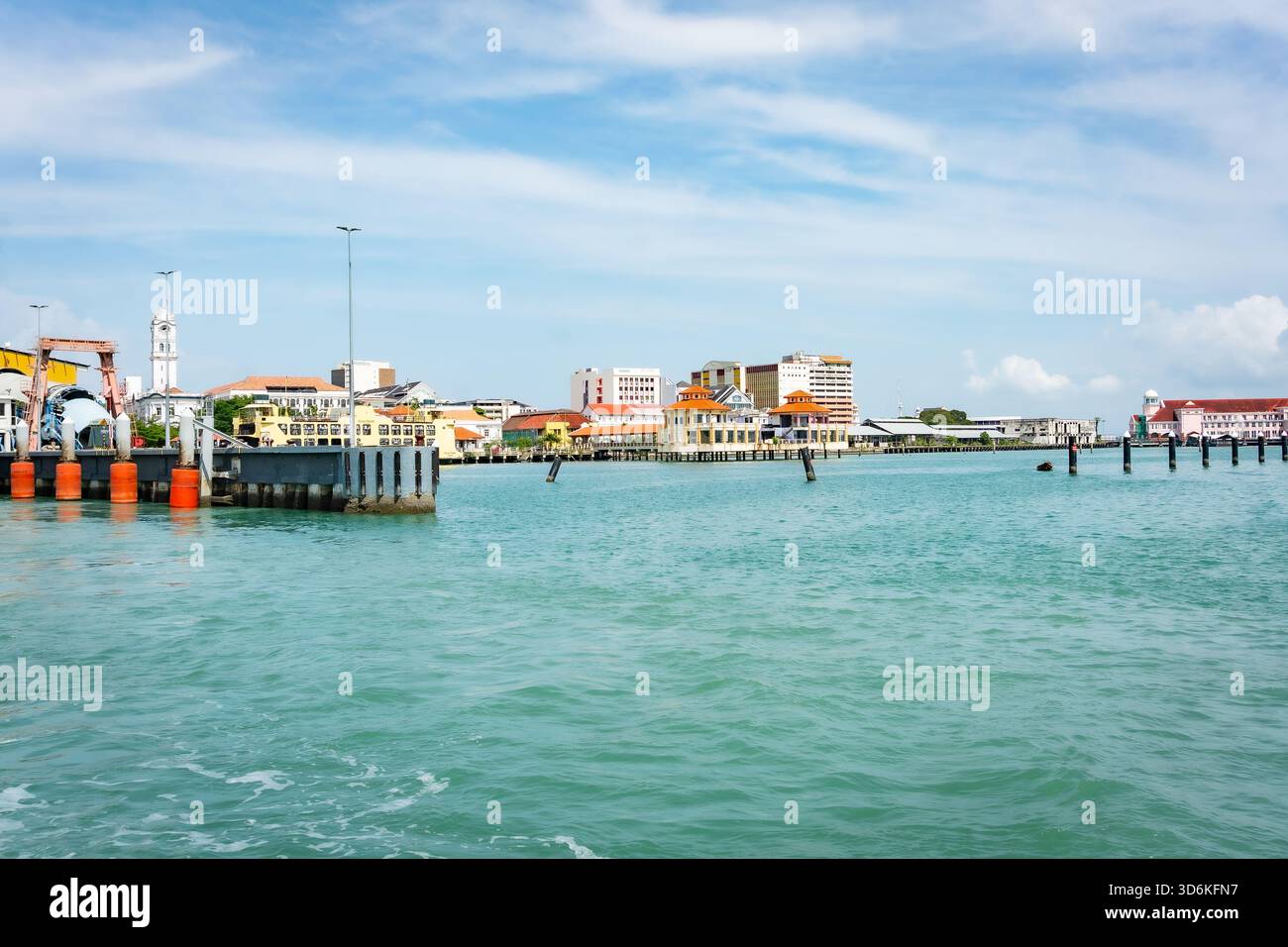 Ein heller Blick auf die Uferpromenade von Georgetown und den Fährhafen in Penang, Malaysia. Die Szene zeigt historische und moderne Gebäude entlang der Küste Stockfoto