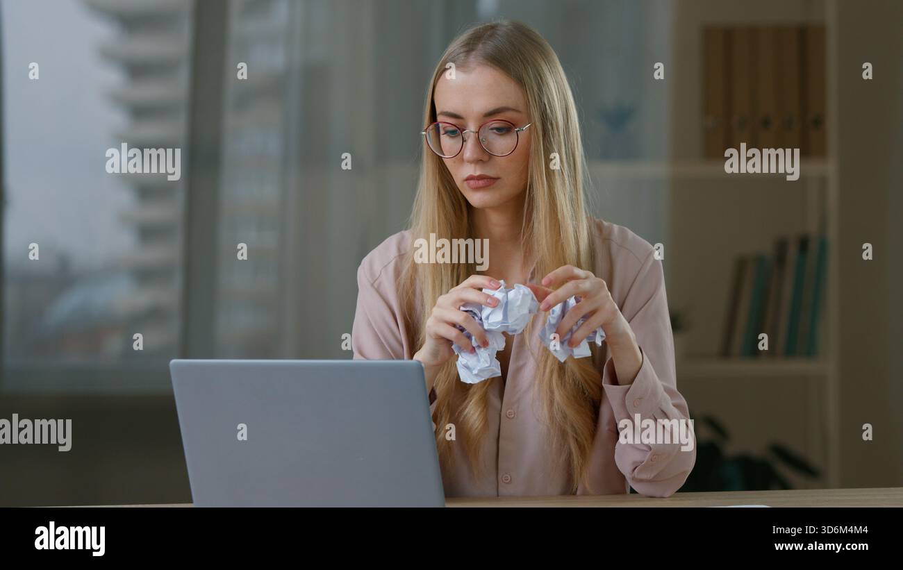 Wütende kaukasische Geschäftsfrau wütend reden Videoanruf werfen Papierkugeln ins Büro gestresste Geschäftsfrau weibliche Unternehmerin reden Stockfoto