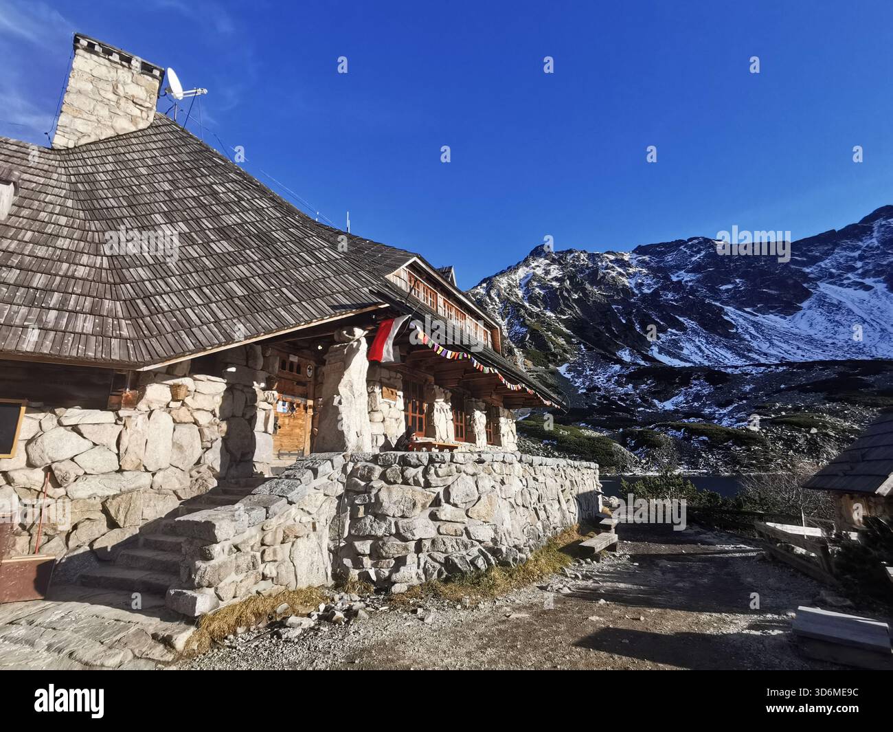 Schronisko Pięciu Stawów, Tatra – Polens höchste Hütte am Przedni Staw-See inmitten schneebedeckter Gipfel im frühen Winter. - Smartphone-aufgenommenes Stockfoto