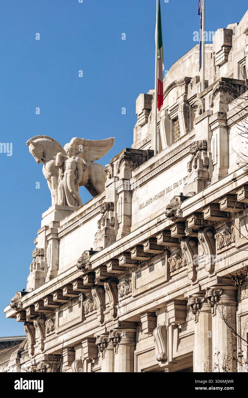 Mailand, Italien - 19. März 2025: Nahaufnahme der monumentalen Steinfassade von Milano Centrale mit detaillierten Skulpturen, darunter ein geflügeltes Pferd und eine menschliche Figur, unter einem klaren blauen Himmel. Stockfoto
