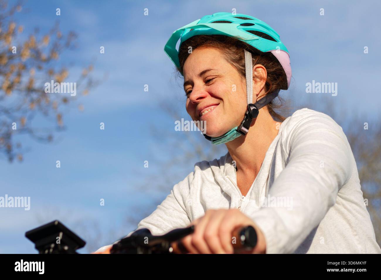 Eine echte Frau, die draußen einen Fahrradhelm trägt Stockfoto