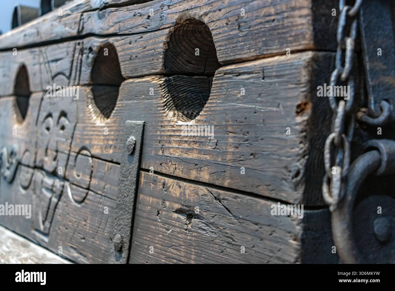 Rostige alte Stämme, Nahaufnahme, historische Foltervorrichtung zur körperlichen Bestrafung mit eisernen Handschellen und einem Loch für die Füße. Stockfoto
