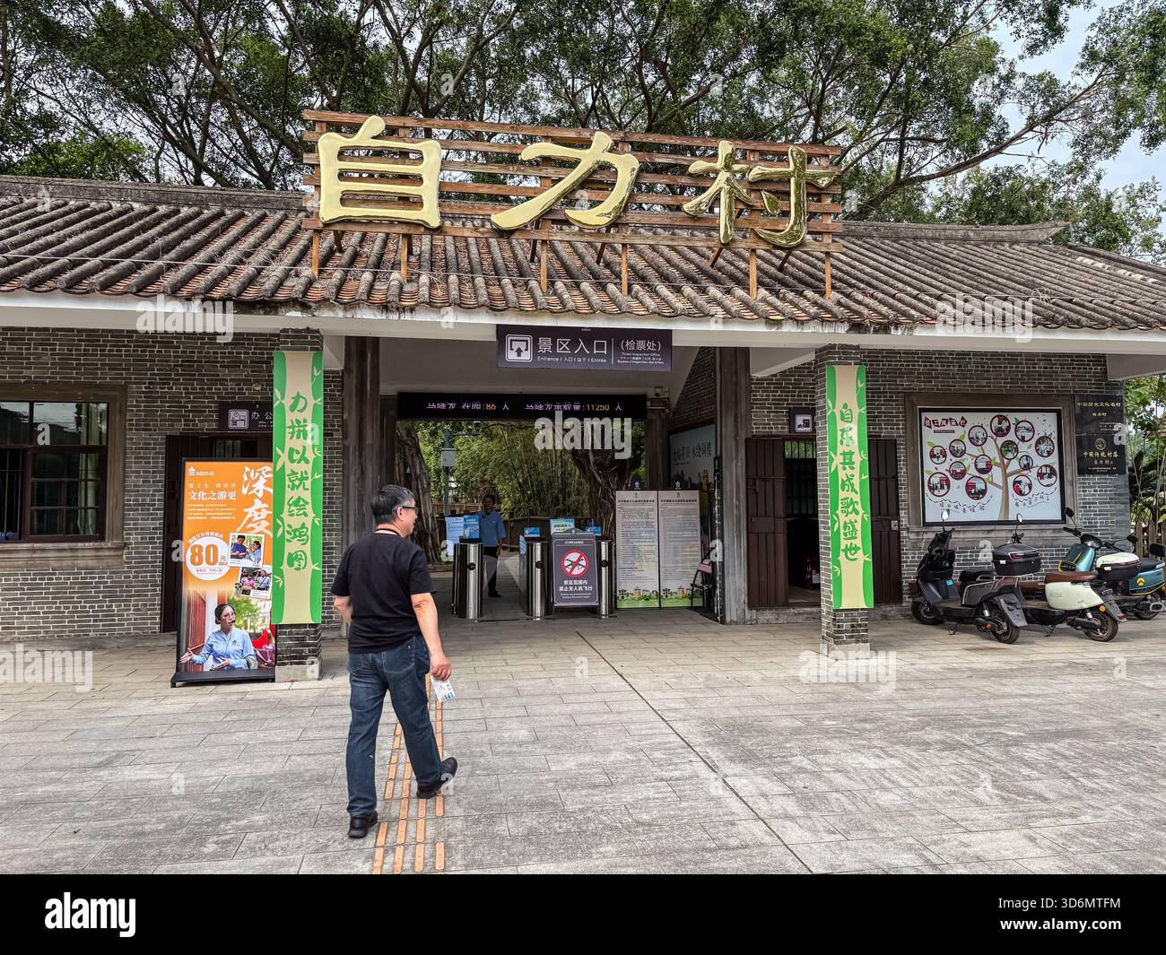Eingangstor des Dorfes Zili in Kaiping, China, bekannt für seine historischen Diaolou (mehrstöckige Wachtürme). Ein Besucher nähert sich dem traditionellen styl Stockfoto