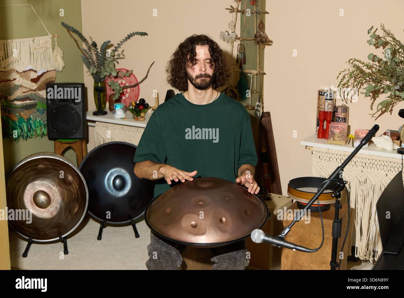 Der Musiker spielt in einem gemütlichen, mit Instrumenten gefüllten Raum die Hand Stockfoto