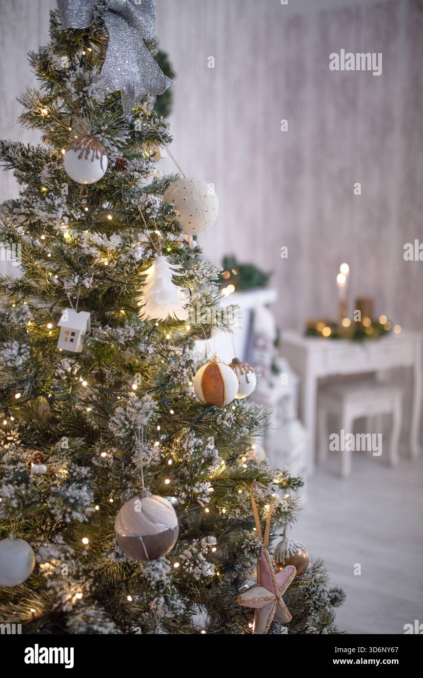 Wunderschön dekorierter Weihnachtsbaum mit funkelnden Lichtern und Ornamenten in einem gemütlichen Zimmer, der einen fröhlichen Weihnachtsgeist und ein festliches Ambiente weckt Stockfoto