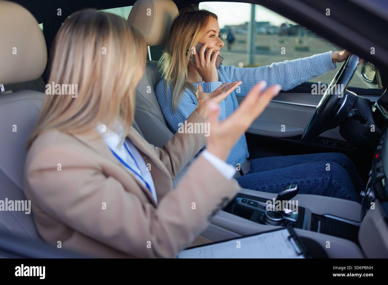 Unsicheres abgelenktes Fahren – der Fahrer spricht während des Unterrichts telefonisch, während der Kursleiter reagiert Stockfoto