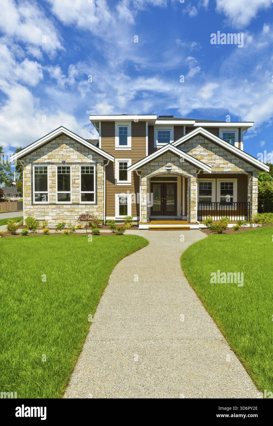Weg zur idealen Wohnhaus in perfekter Umgebung. Marke neue Familie Haus mit großen, grünen Wiese vor blauem Himmel Hintergrund Stockfoto